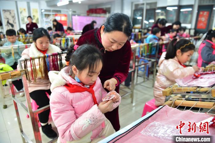 江西省級(jí)非遺豫章繡傳承人手把手指導(dǎo)小學(xué)生繡制2022年北京冬奧會(huì)吉祥物“冰墩墩”形象?！∮髟屏?攝