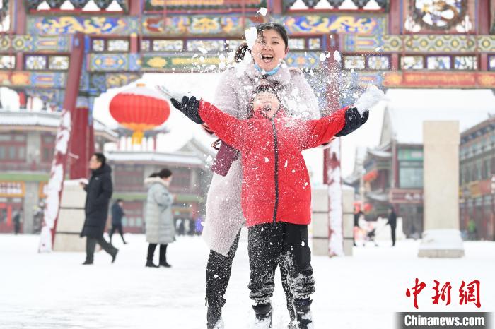 2月13日，家長與小朋友在呼和浩特市大召廣場享雪趣?！⑽娜A 攝