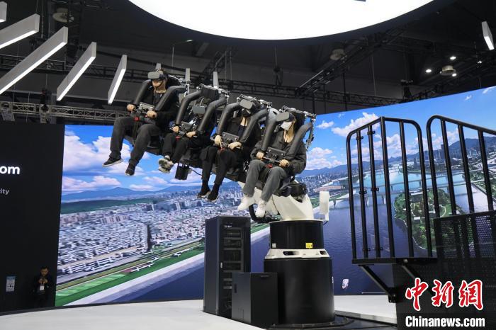 圖為觀眾在展會(huì)模擬體驗(yàn)未來(lái)城市空中移動(dòng)出行方式?！⑿?攝