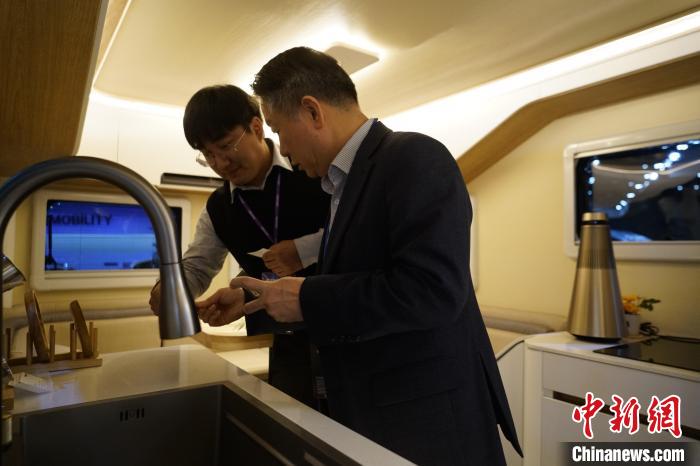 圖為參展商向觀眾介紹房車內(nèi)部設(shè)計(jì)?！⑿?攝