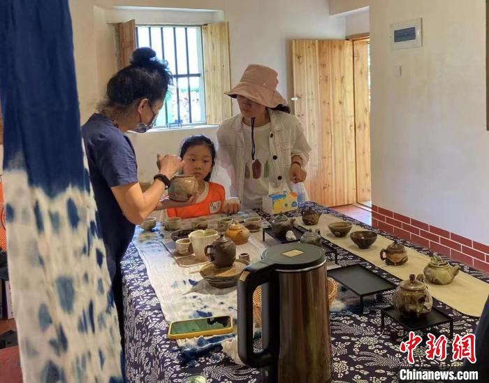 圖為：游客正在咨詢臺(tái)灣柴燒作品?！∪~秋云 攝