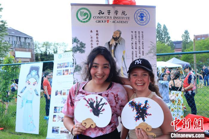 孩子們展示自己的吹墨畫團扇作品?！◆斻肟鬃訉W院供圖