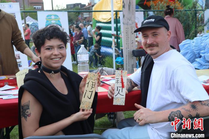 當?shù)孛癖娫跐h字體驗工作坊展示自己手寫的中文名書簽?！◆斻肟鬃訉W院供圖