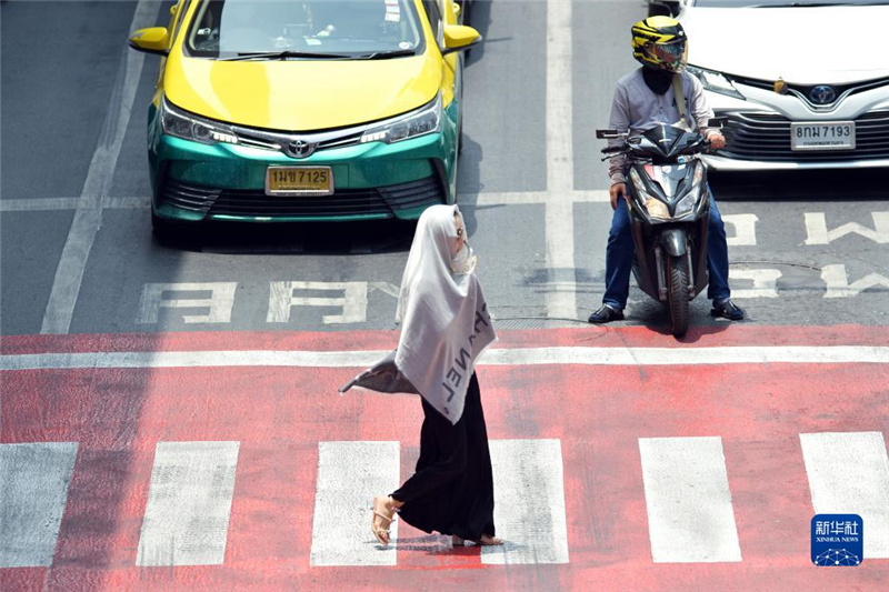 5月17日，行人在泰國(guó)曼谷街頭用圍巾遮陽(yáng)。新華社發(fā)（拉亨攝）