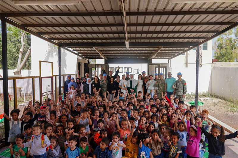 當?shù)貢r間5月30日，黎巴嫩南部庫雷拉公立小學，“六一”國際兒童節(jié)前夕，中國第21批赴黎維和多功能工兵分隊官兵看望慰問學校師生，并開展文化交流活動，圖為我維和官兵同師生合影。李竹林攝