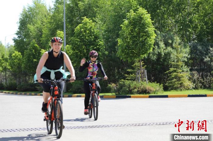 亞信副秘書長遲方(右一)與聯(lián)合國駐哈協(xié)調(diào)員在騎行活動(dòng)中?！喰琶貢幑﹫D