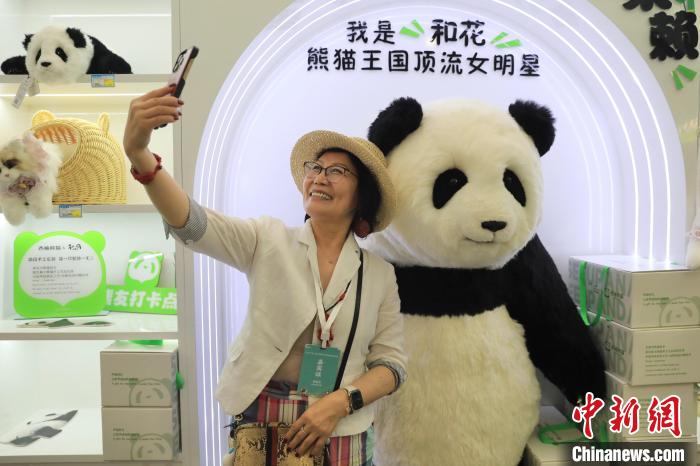 美國華視總裁楊蓮花與大熊貓文創(chuàng)產(chǎn)品合影。　王磊 攝