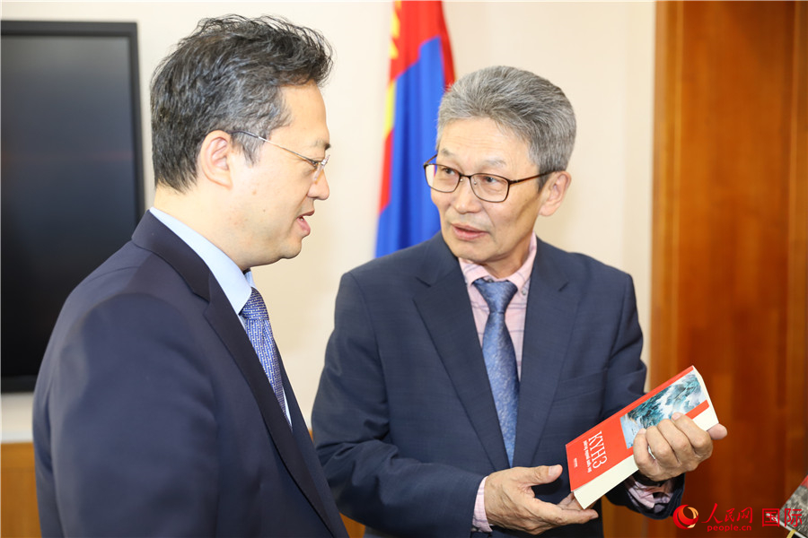 其米德策耶（右一）向李峙介紹翻譯成果。人民網(wǎng)記者 霍文攝