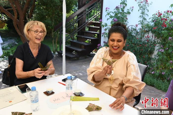 圖為嘉賓展示包粽子成果?！“亓种袊?guó)文化中心供圖。