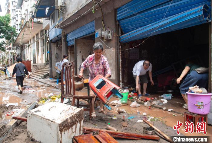 7月4日，萬州區(qū)五橋街道，洪水退去后，居民搶救生活物資?！∪矫宪?攝
