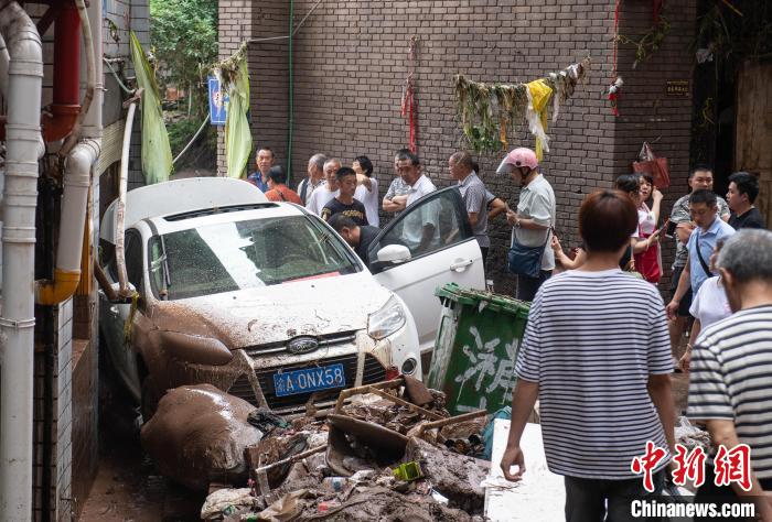 7月4日，萬州區(qū)五橋街道，居民救援受困的私家車。　冉孟軍 攝