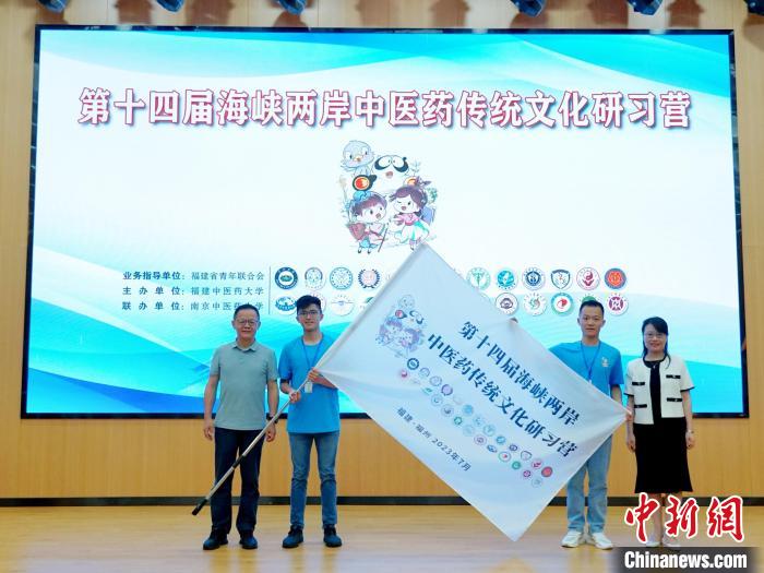 共青團(tuán)福建省委副書記吳雪(右一)、福建中醫(yī)藥大學(xué)黨委副書記林羽(左一)為兩岸學(xué)生代表頒授營旗?！≡S燁婷 攝