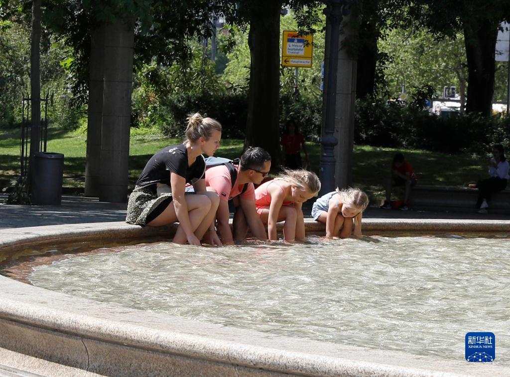 7月8日，人們在德國法蘭克福的一處噴泉玩水。近日，德國法蘭克福逐漸迎來暑熱天氣。新華社記者 張帆 攝