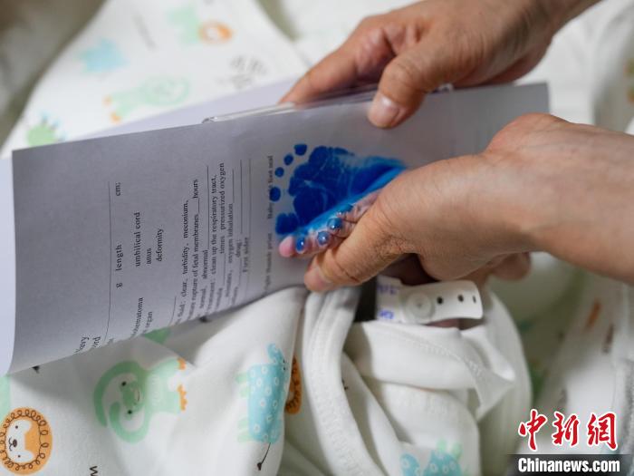 醫(yī)護人員為新生兒留下腳印。　劉偉 攝