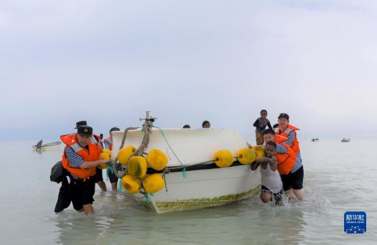 7月21日，中國海軍“和平方舟”號(hào)醫(yī)院船醫(yī)護(hù)人員涉水登島，前往基里巴斯一診療點(diǎn)。新華社記者 黎云 攝