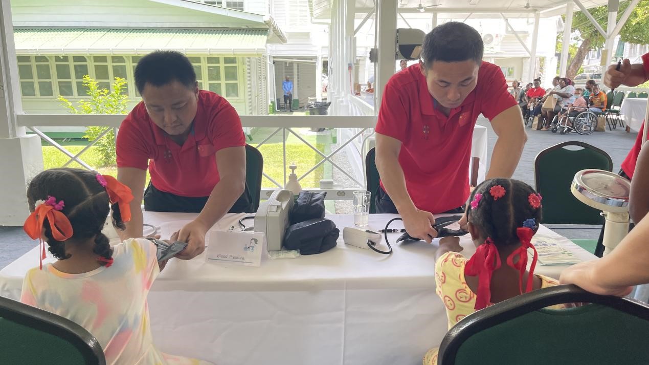 醫(yī)療隊員為福利院兒童進行檢查。第18期援圭亞那醫(yī)療隊供圖