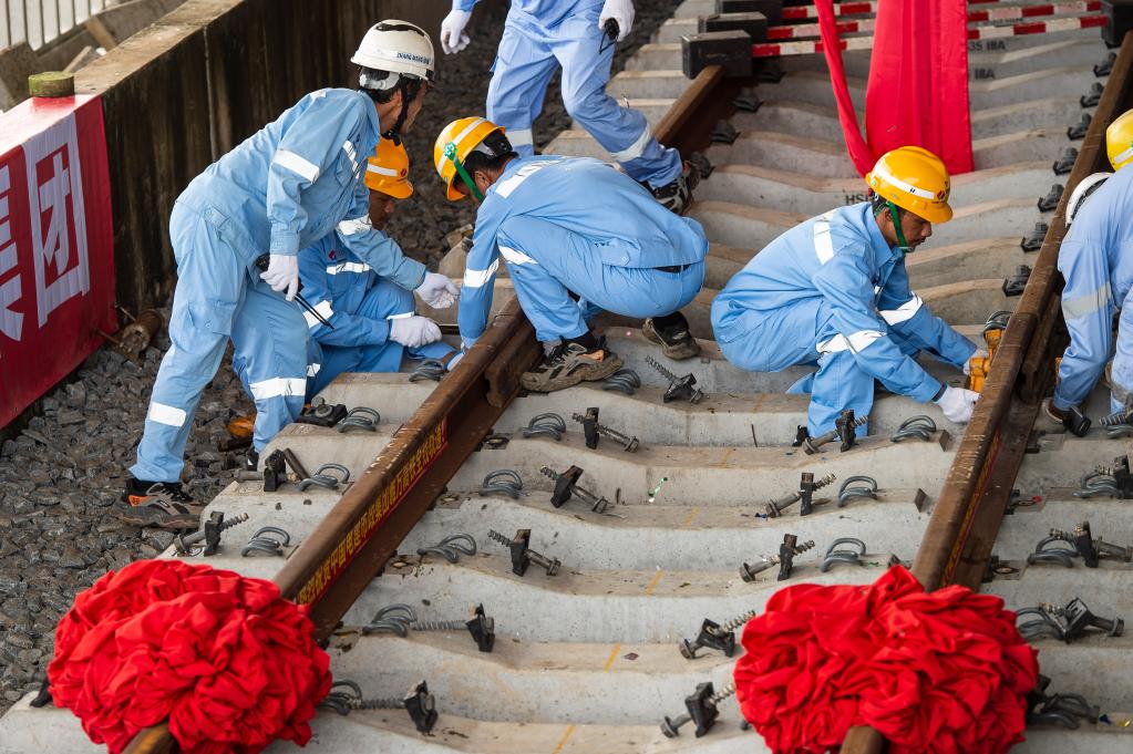 3月31日，在印度尼西亞雅加達雅萬高鐵哈利姆車站，工人鋪設(shè)雅萬高鐵全線最后一根鋼軌。