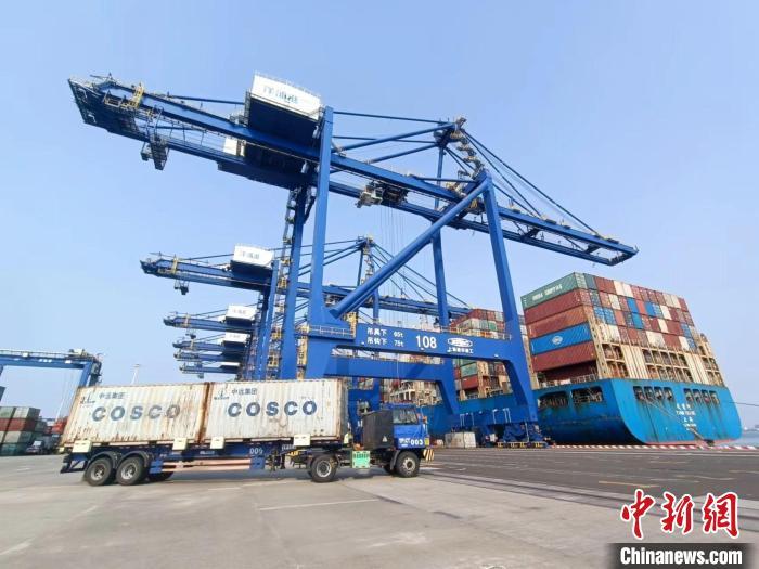 圖為海南洋浦國(guó)際集裝箱碼頭，卡車(chē)將集裝箱從后方堆場(chǎng)運(yùn)往碼頭裝卸區(qū)。　張?jiān)潞?攝