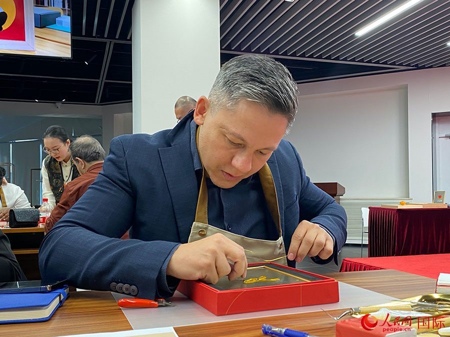 2023“一帶一路”媒體合作論壇聯(lián)合采訪團(tuán)團(tuán)員，親身體驗景泰藍(lán)工藝。人民網(wǎng)記者 于洋攝