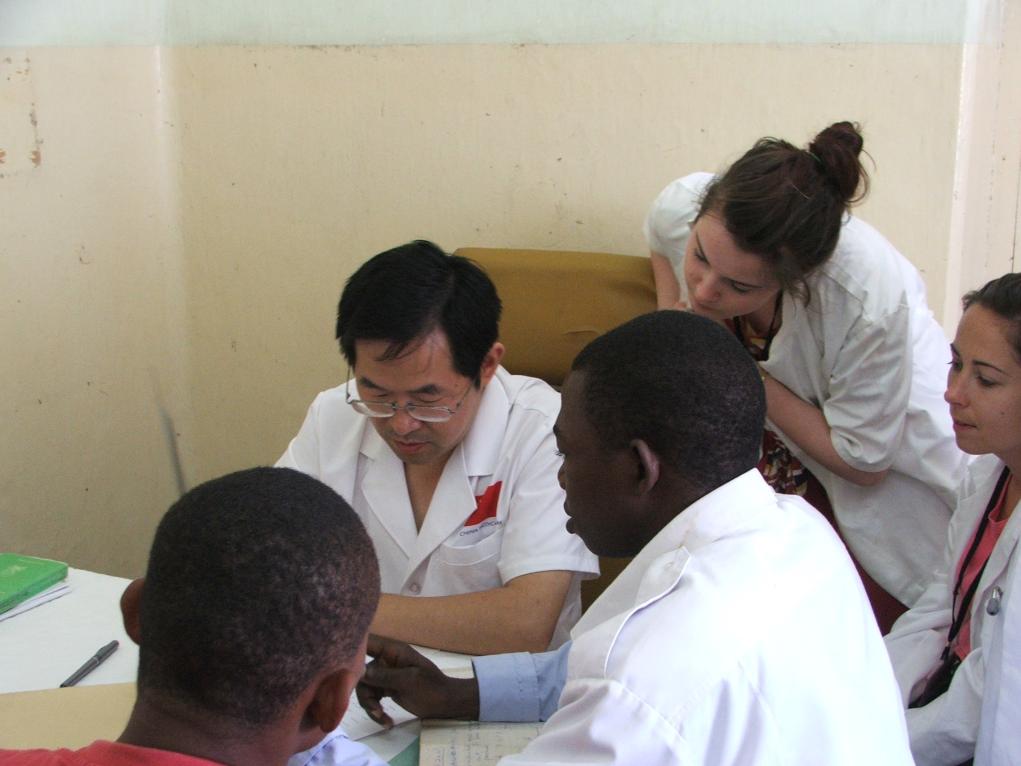 2011年7月22日，在坦桑尼亞桑給巴爾納茲莫加醫(yī)院外科門(mén)診，中國(guó)第24批援桑給巴爾醫(yī)療隊(duì)隊(duì)長(zhǎng)盧建林為當(dāng)?shù)鼗颊咴\治并帶教實(shí)習(xí)生。新華社發(fā)（國(guó)家衛(wèi)生健康委供圖）