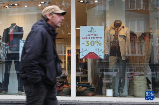   10月31日，一名男子從比利時(shí)布魯塞爾一家貼有打折信息的店鋪前走過。新華社記者 趙丁喆 攝