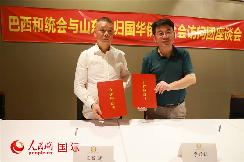 中國僑聯(lián)副主席、山東省僑聯(lián)主席李興鈺（右）與巴西和統(tǒng)會會長王俊曉簽署合作協(xié)議書。人民網(wǎng)記者 陳海琪攝