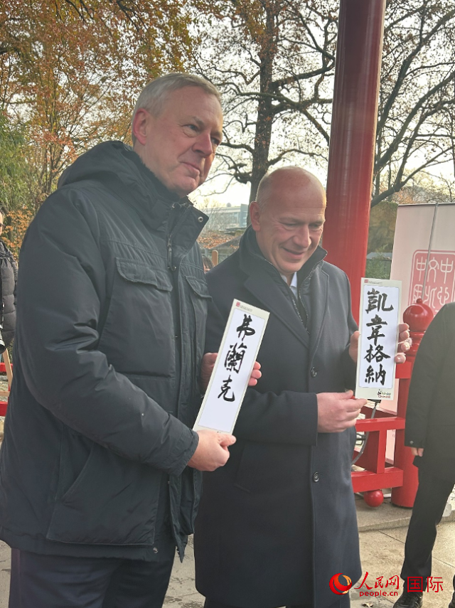 柏林市長韋格納（右）、動物園監(jiān)事會主席布魯克曼（左）手持中國文化中心工作人員現(xiàn)場手書的中文名字。人民網(wǎng)記者 徐馨攝