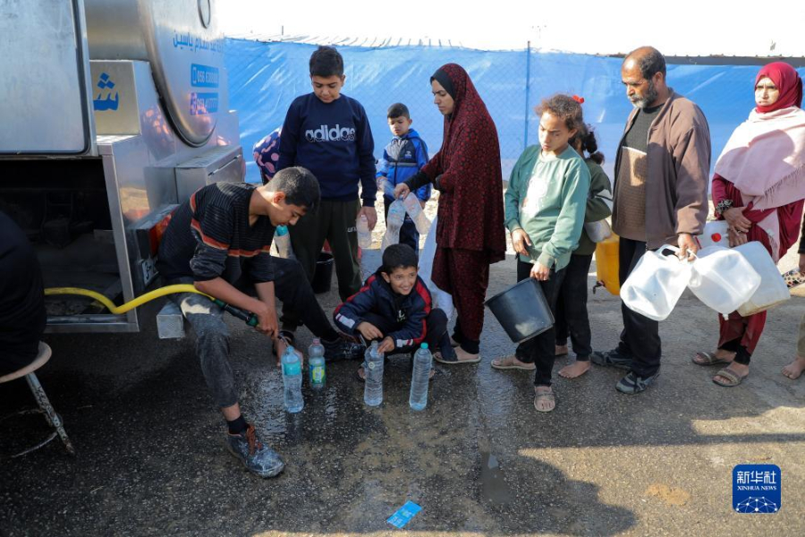 12月8日，在加沙地帶南部城市拉法一處臨時(shí)營(yíng)地內(nèi)，人們排隊(duì)打水。新華社發(fā)（里澤克·阿卜杜勒賈瓦德 攝）