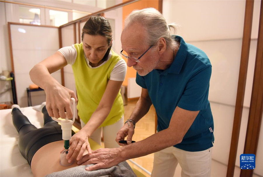 12月12日，在奧地利維也納，科格勒醫(yī)生（右）和助手在為病人進(jìn)行拔罐治療。新華社記者 賀燦鈴 攝