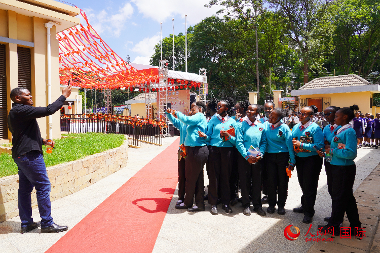 一名老師在給學生拍照留念。人民網(wǎng)記者 黃煒鑫攝