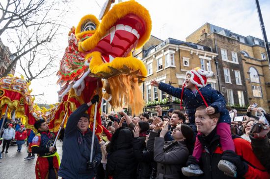 2月11日，人們在英國倫敦的新春巡游活動中觀看舞龍表演。新華社發(fā)（史蒂芬·程攝）