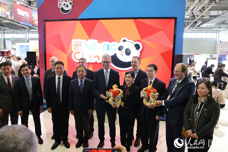 參加中國館開幕式的嘉賓們在“你好 中國” 展臺前合影留念。