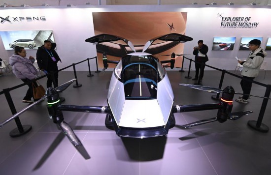 2023年12月1日，在鏈博會智能汽車鏈展區(qū)小鵬汽車展臺，參觀者觀看一臺智能飛行器。新華社記者蔡湘鑫攝