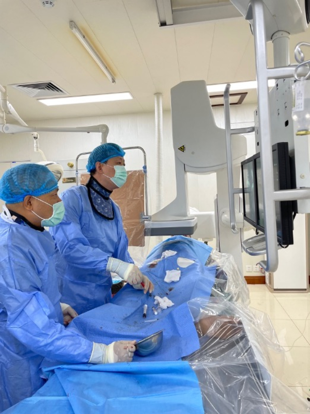 李凱教授（右）和劉海濤教授（左）為患者行TACE手術(shù)。中國(guó)駐老撾大使館供圖