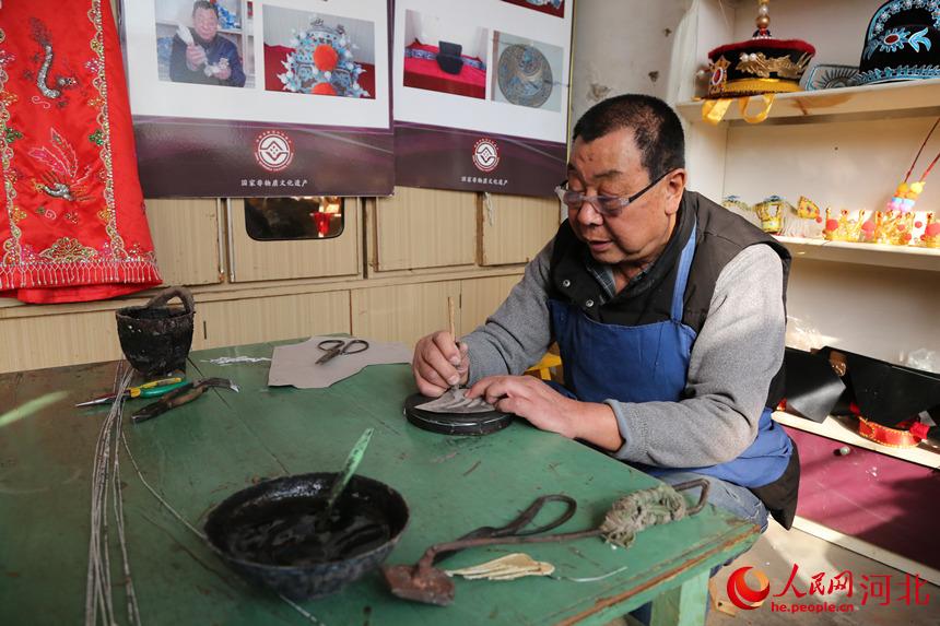 戲曲盔頭技藝傳承人許茂臣正在足活。 韓冰攝