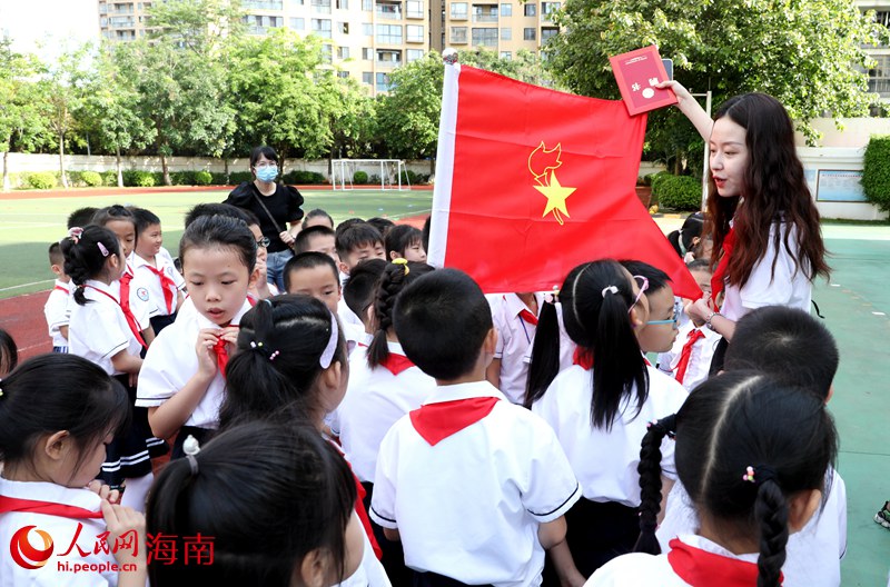 老師向少先隊(duì)員展示隊(duì)旗。人民網(wǎng) 符武平攝