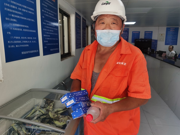 1環(huán)衛(wèi)工倪建宏小憩后，為還同事帶去冷飲。人民網(wǎng)記者王繼亮攝