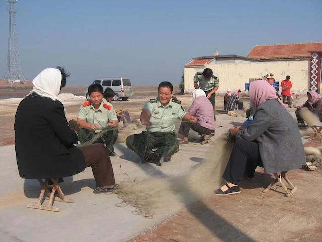 宋萬民幫助漁民修補漁網。 濱州市公安局海岸警察支隊岔尖派出所供圖