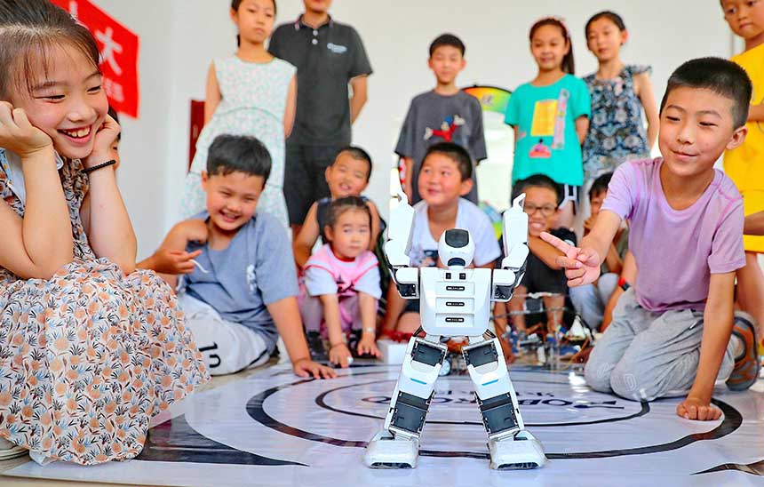 2022年7月19日，河北省秦皇島市海港區(qū)白塔嶺街道秦皇半島第二社區(qū)內(nèi)，小朋友正在觀看“機器人跳舞”。 曹建雄攝