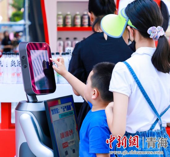 圖為一名小朋友正在和機(jī)器人“志愿者”進(jìn)行互動(dòng)。 沐聞 攝