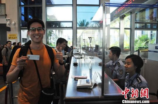  4月30日上午，從美蘭機(jī)場(chǎng)入境的新加坡旅客接過?？诿捞m邊檢站民警的溫馨提示小卡片后豎起大拇指點(diǎn)贊?！±盍濉z