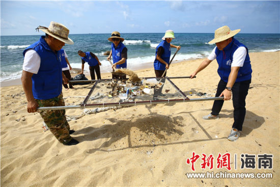 環(huán)保志愿者用篩網(wǎng)“淘”出海灘上的垃圾。