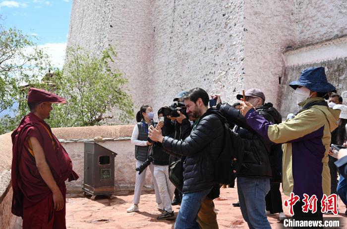 圖為中外媒體拍攝朝拜布達拉宮的僧人?！≮w朗 攝