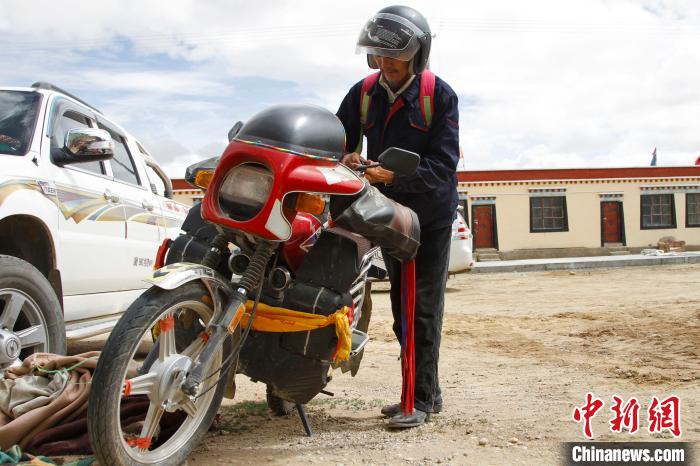 圖為白瑪準備騎摩托車巡湖?！≮w朗 攝