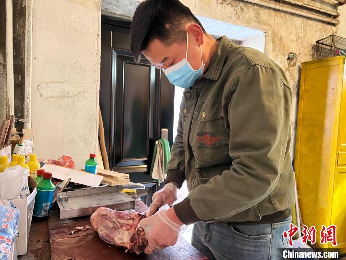 圖為雪豹“奶爸”史壽軍正在準(zhǔn)備投喂雪豹的食材?！●R銘言 攝