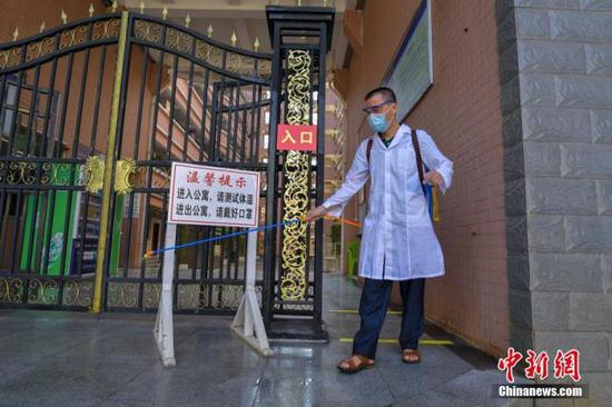 資料圖：?？诮?jīng)濟學(xué)院的工作人員在學(xué)生宿舍樓入口消毒。 中新社記者 駱云飛 攝