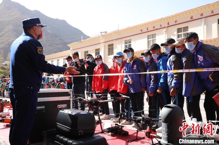 圖為消防指戰(zhàn)員為學生講解、演示先進救援裝備。　趙琳 攝