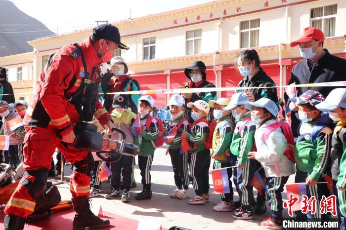 圖為消防指戰(zhàn)員為學生講解、演示先進救援裝備?！≮w琳 攝