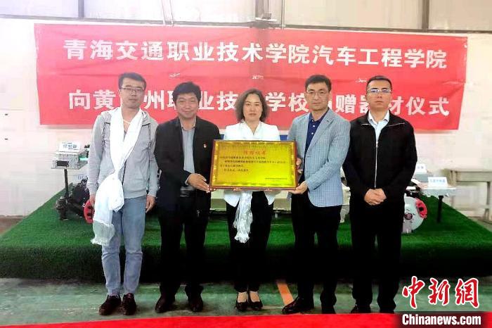 圖為李富香(中)代表學(xué)校為州縣技校捐贈(zèng)器材。(資料圖) 青海省教育廳供圖