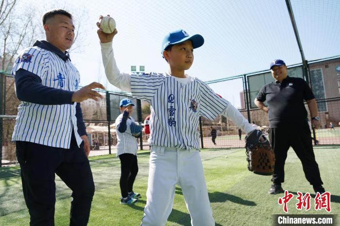 圖為教練指導(dǎo)小棒球手擲球技術(shù)。　馬銘言 攝